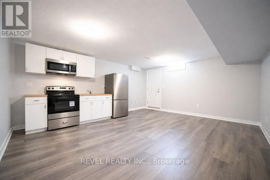 A kitchen with white cabinets and a stainless steel refrigerator.