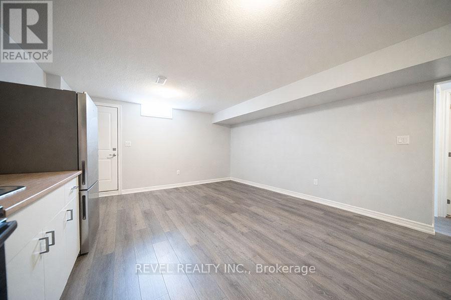 A spacious room with a kitchen area to the left and a doorway leading to another room.