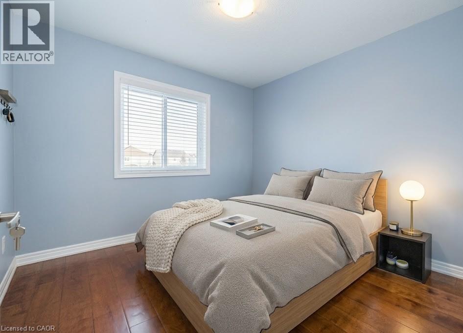A bedroom with a bed, nightstand, and window.