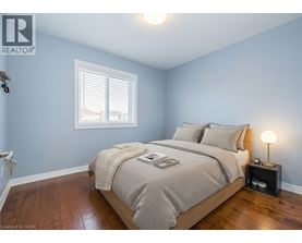 A bedroom with a bed, nightstand, and window.