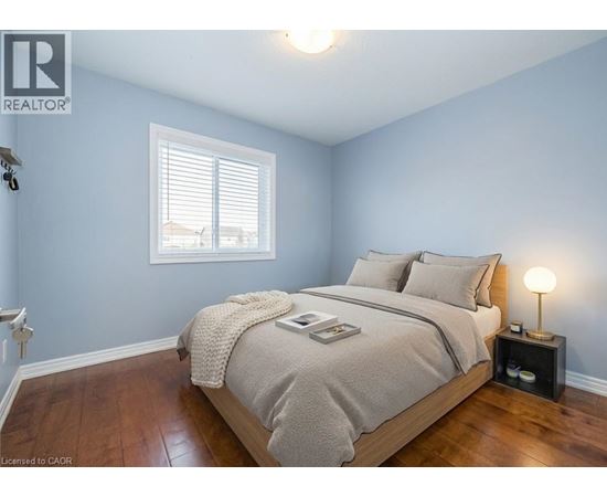 A bedroom with a bed, nightstand, and window.
