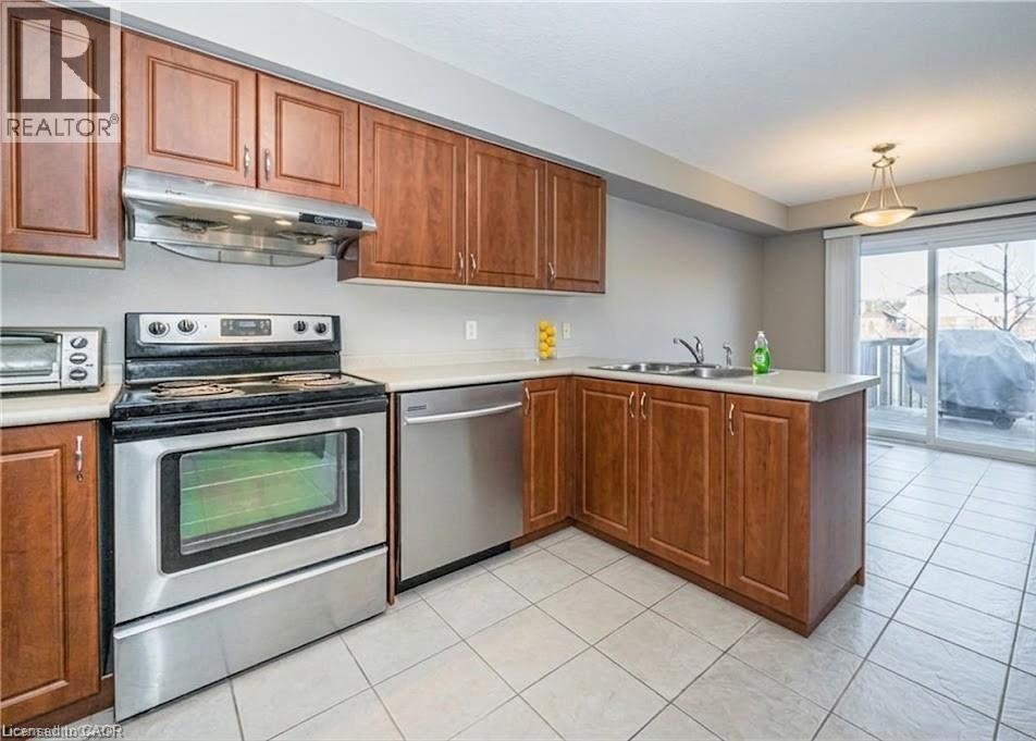 A kitchen with wooden cabinets and a stainless steel oven.