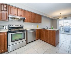 A kitchen with wooden cabinets and a stainless steel oven.