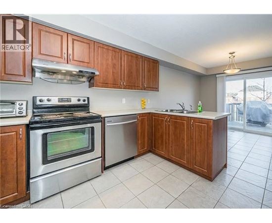 A kitchen with wooden cabinets and a stainless steel oven.