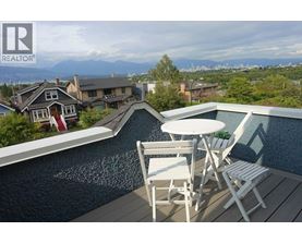 A poolside table with chairs overlooks a residential area.
