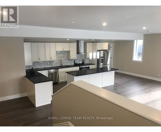 A modern kitchen with a large island and stainless steel appliances.