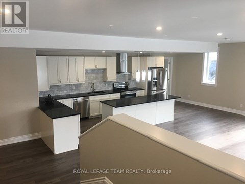 A modern kitchen with a large island and stainless steel appliances.