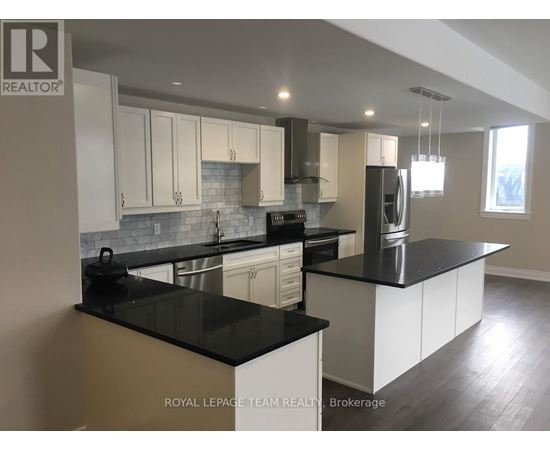 A kitchen with black countertops and white cabinets.