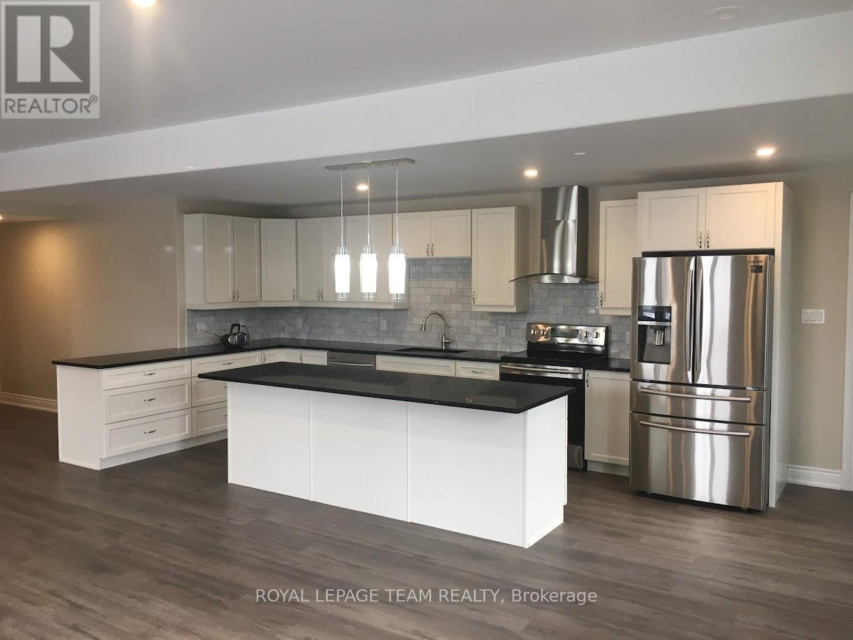 A modern kitchen with a large island and stainless steel appliances.