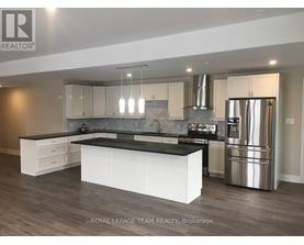 A modern kitchen with a large island and stainless steel appliances.