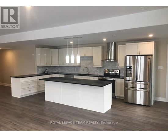 A modern kitchen with a large island and stainless steel appliances.
