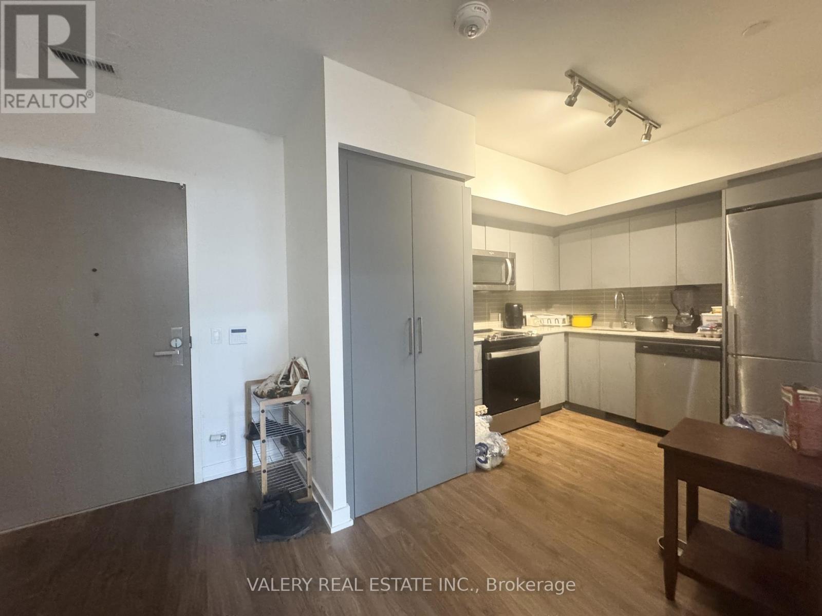 A kitchen with a refrigerator, oven, and microwave.