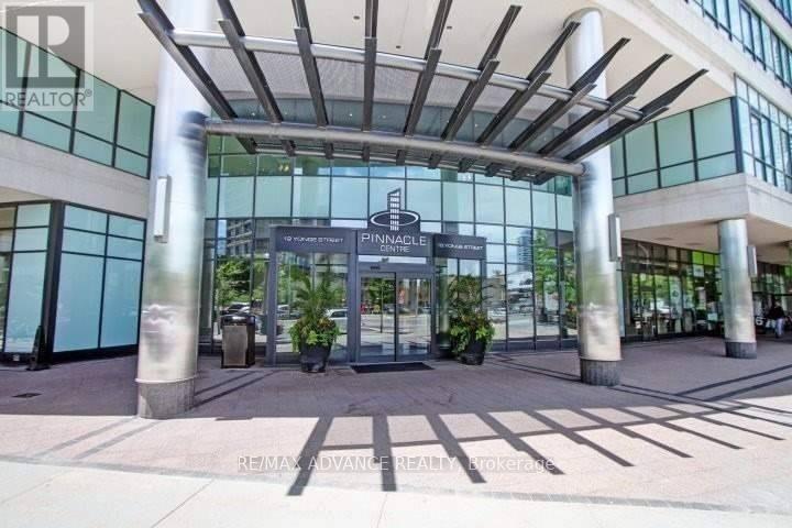 The entrance to a building with a glass facade and a sign that reads "Pinnacle".