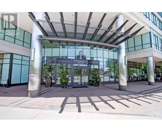The entrance to a building with a glass facade and a sign that reads "Pinnacle".