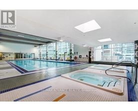 A large indoor swimming pool with a hot tub in the middle.