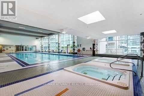 A large indoor swimming pool with a hot tub in the middle.