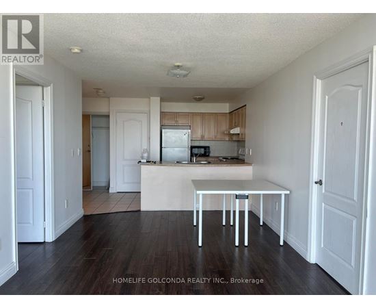 A white table is in the middle of a kitchen with wood floors.