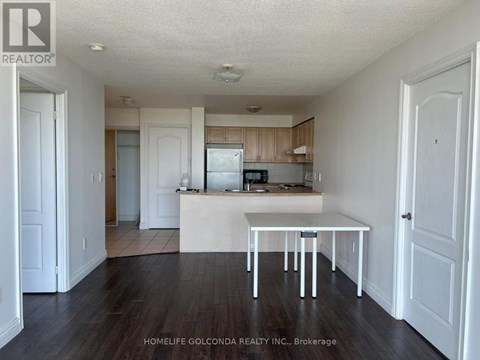 A white table is in the middle of a kitchen with wood floors.