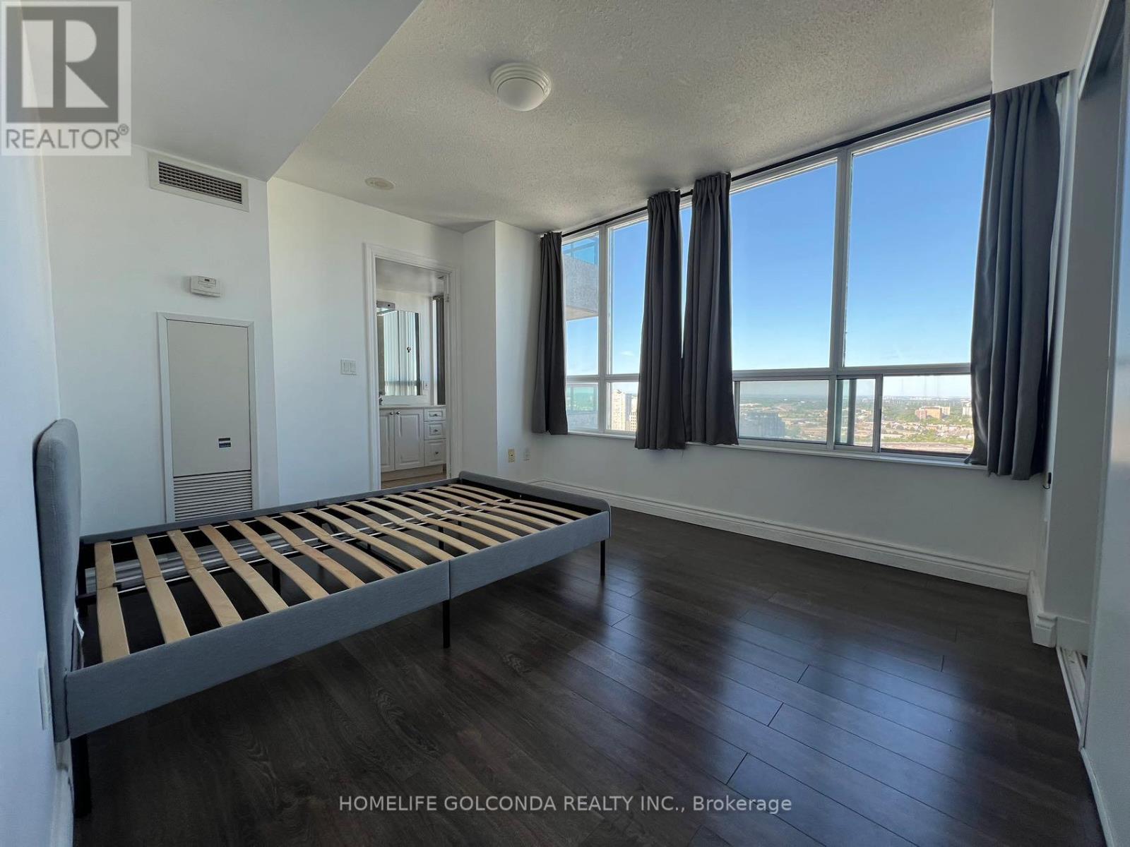 A bedroom with a large bed and a view of the city.