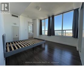 A bedroom with a large bed and a view of the city.