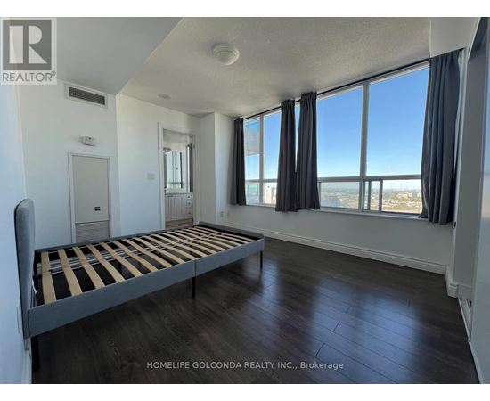 A bedroom with a large bed and a view of the city.