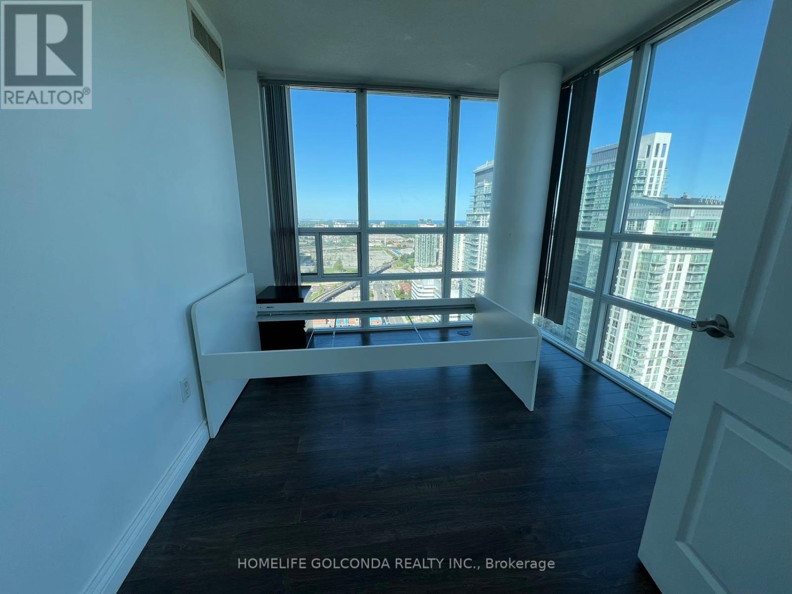 A room with a large window overlooking a cityscape.