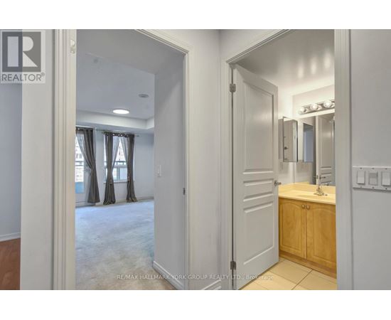 A bathroom with a sink, mirror, and a door leading to a bedroom.