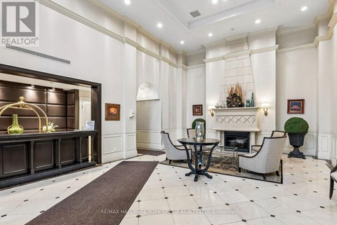 A well-lit, elegant living room with a fireplace and a dining table set up.