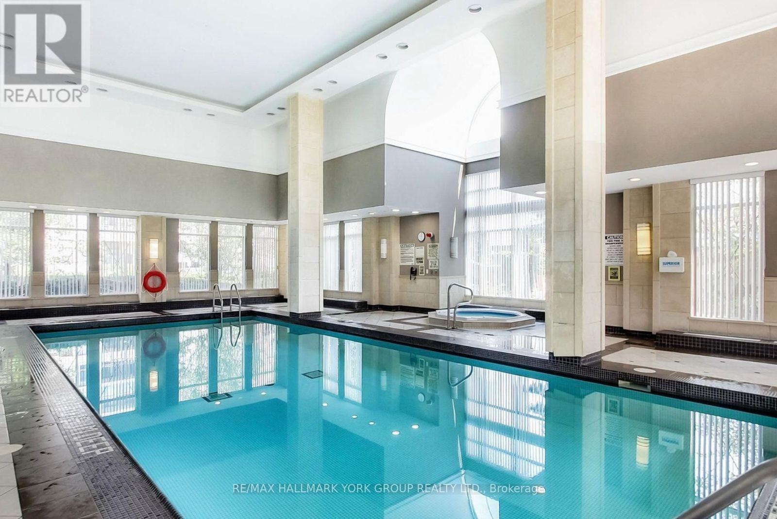 A large indoor swimming pool with a diving board.