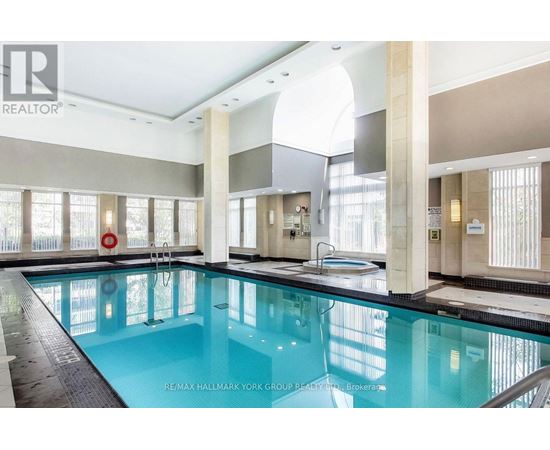 A large indoor swimming pool with a diving board.