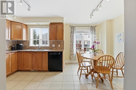 A kitchen with wooden cabinets and a dining table with chairs.