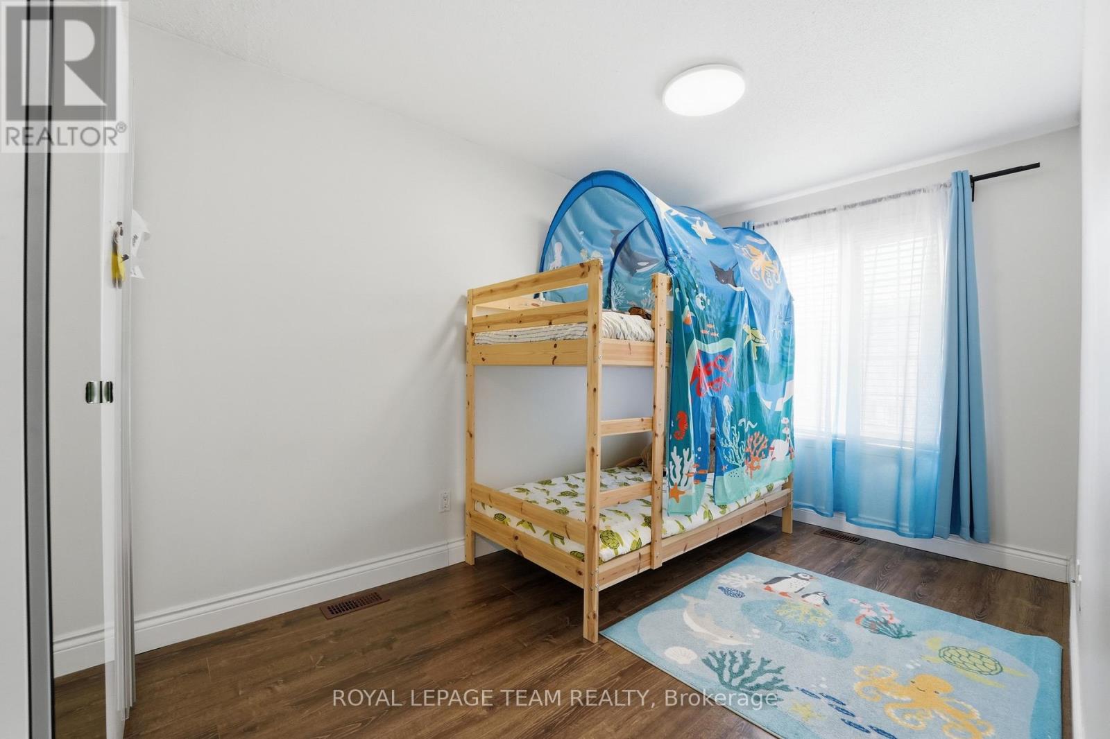 A bedroom with a bunk bed and a blue carpet.