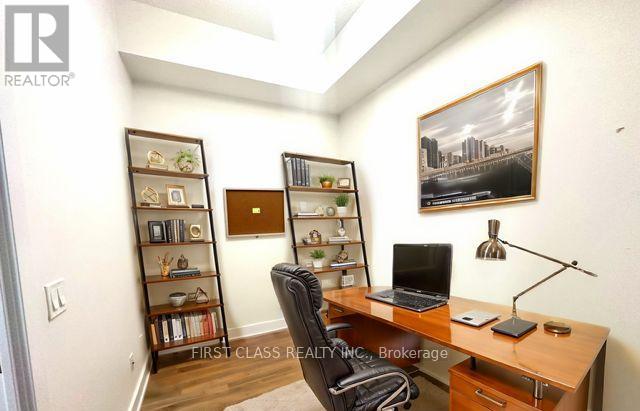 A realtor's office with a desk, chair, and bookshelves.