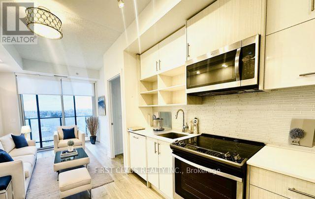 A modern kitchen with a black stove top oven and white cabinets.