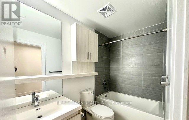 A bathroom with a toilet, sink, and bathtub.