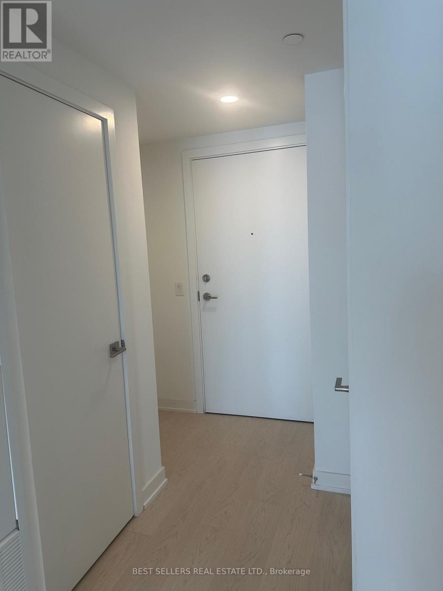 A hallway with white walls and a wooden floor.