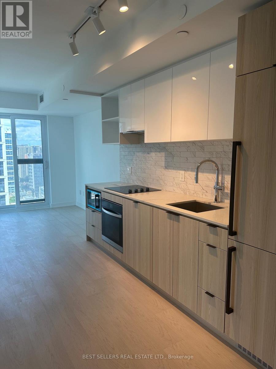 A modern kitchen with wooden cabinets and a marble backsplash.
