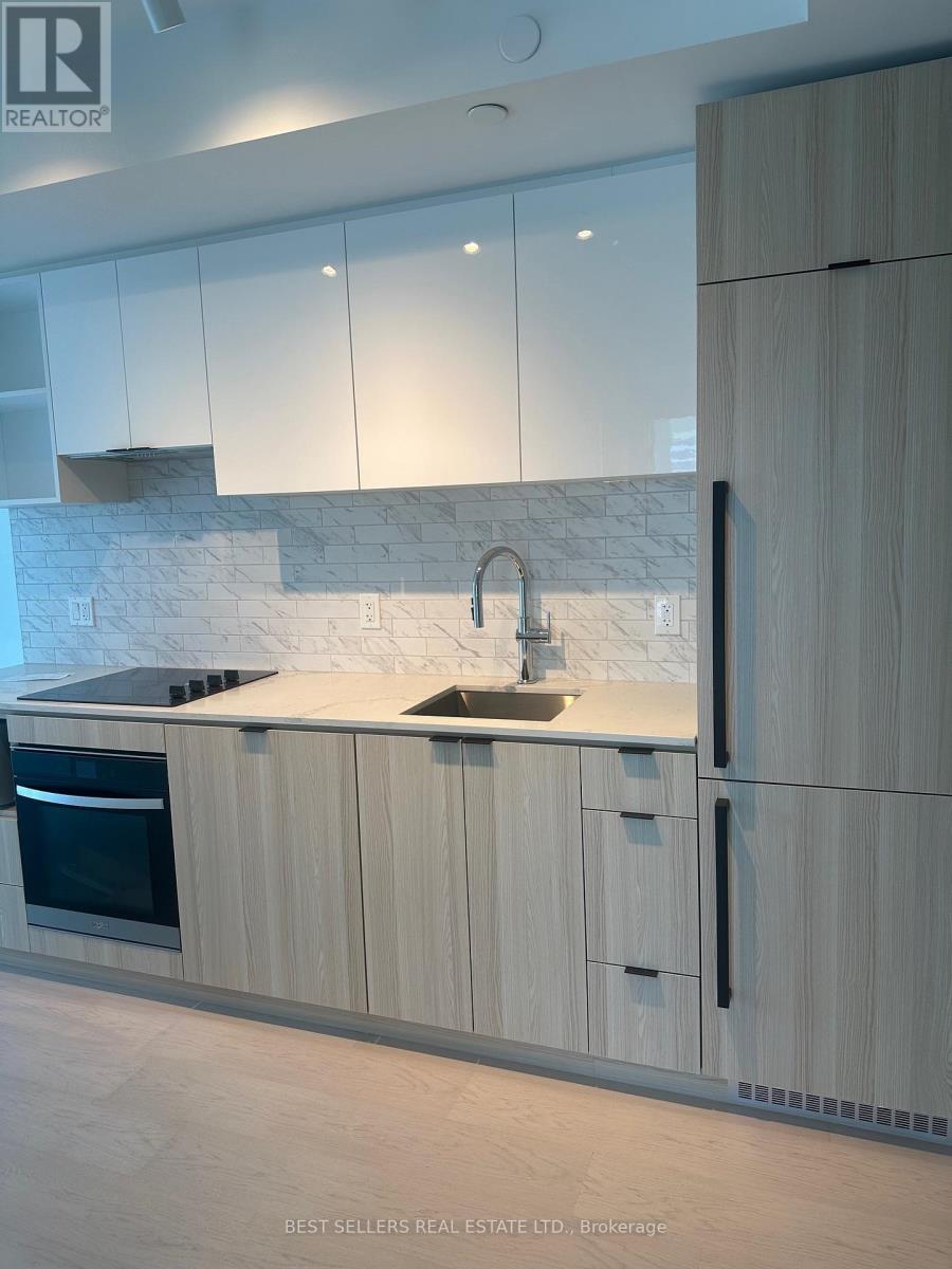 A modern kitchen with white cabinets and a marble backsplash.
