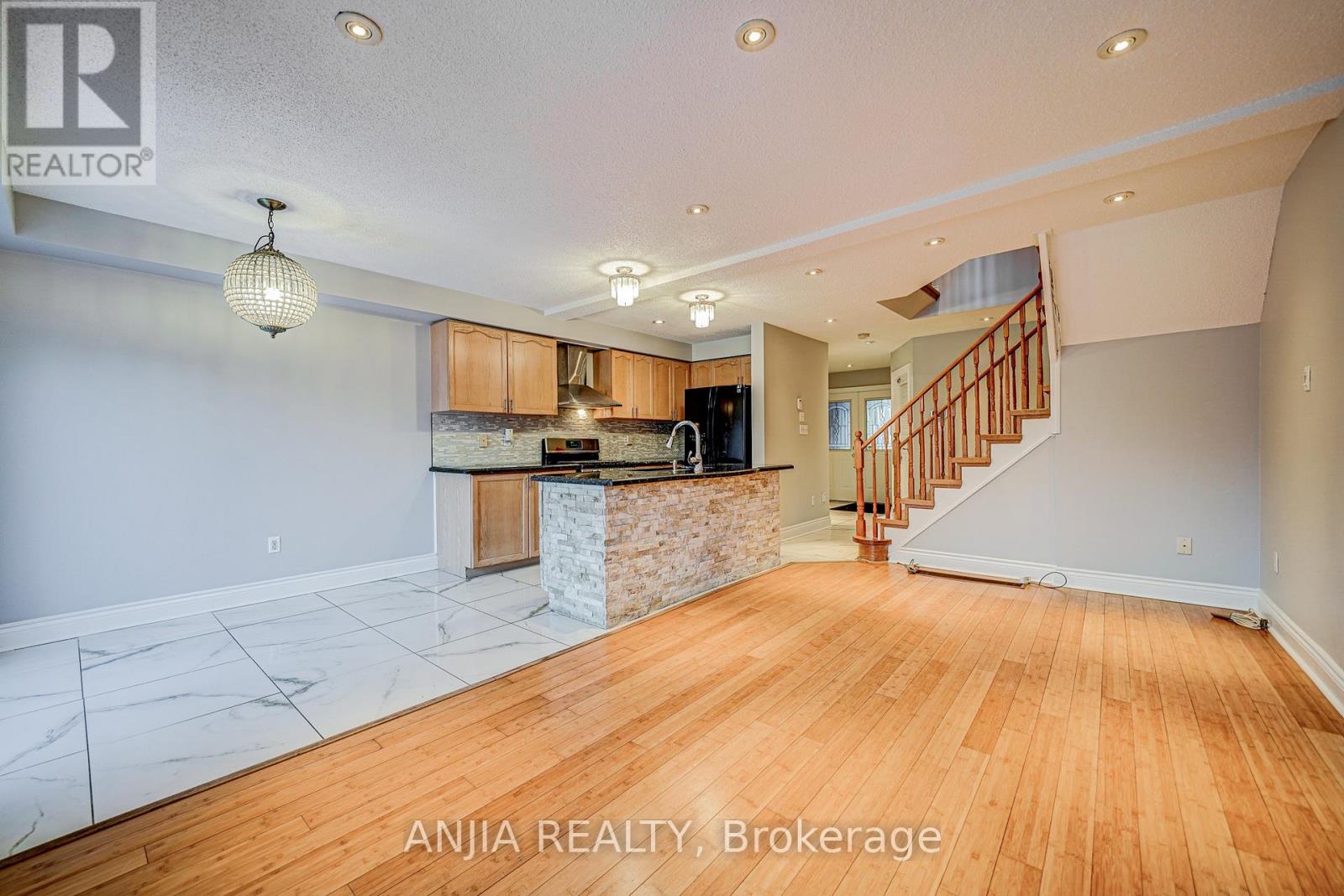A spacious room with wooden floors and a marble countertop.