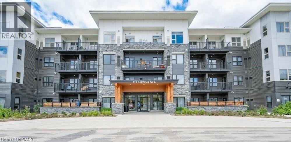 A large apartment complex with a central entrance and balconies on the upper floors.