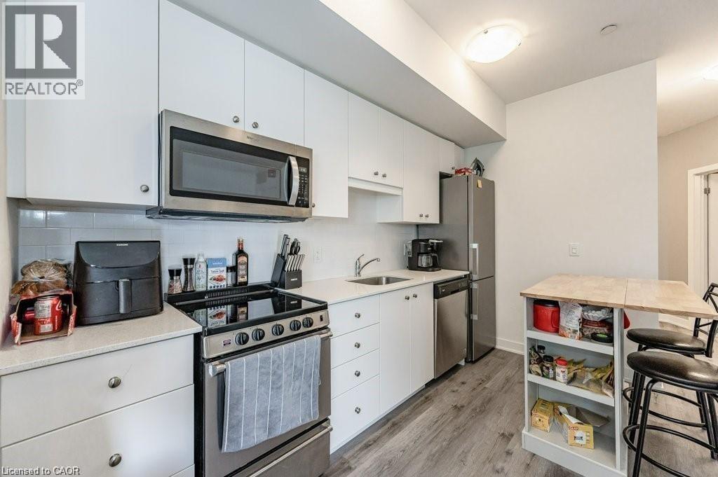 A kitchen with white cabinets and a microwave above the stove.