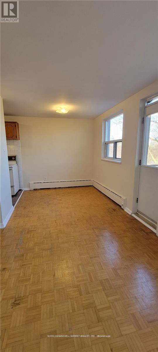 A room with wooden flooring and a window.