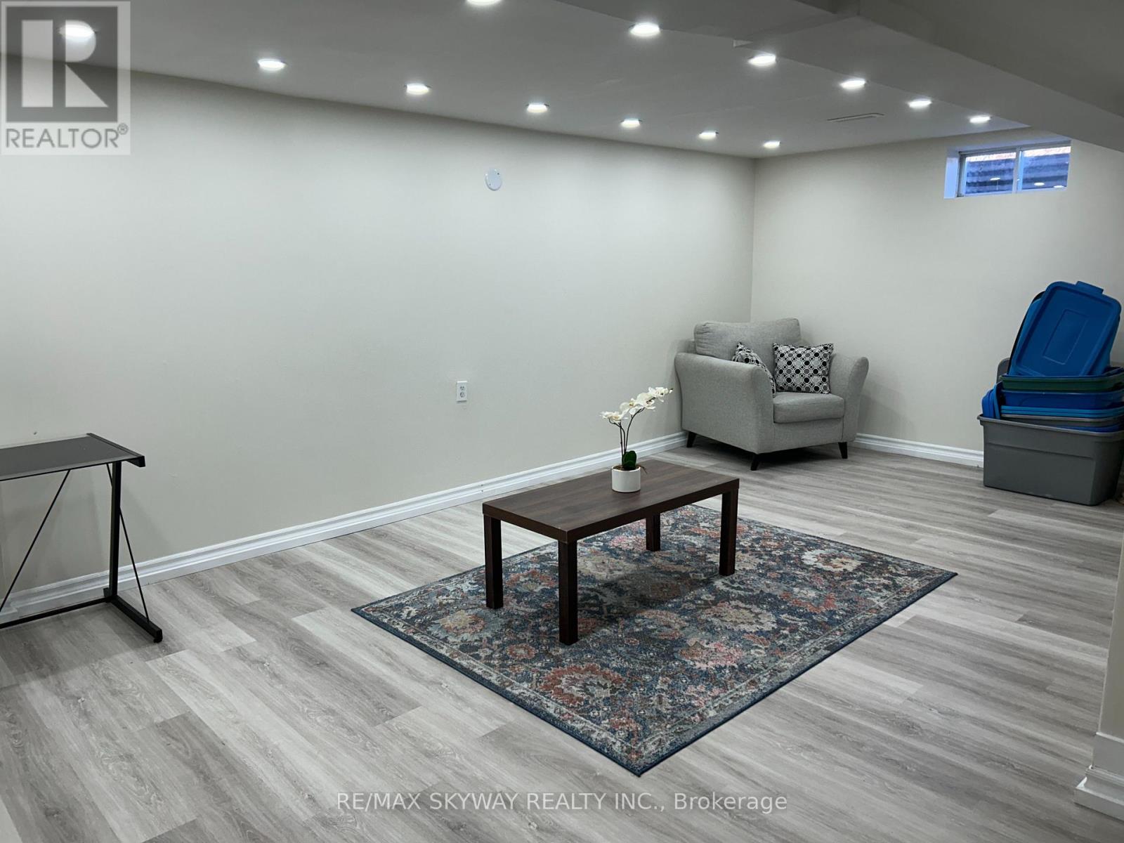 A room with a wooden table and a sofa in the background.