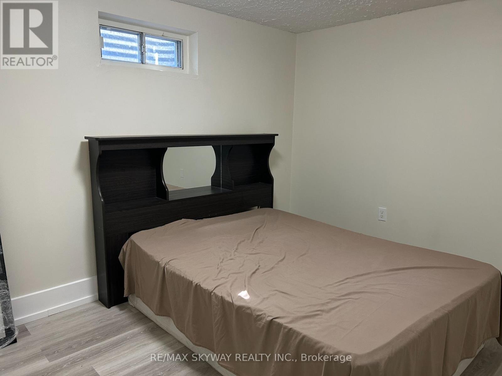 A bedroom with a bed and a window.