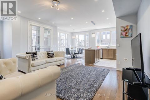 A modern living room with a white sofa and a grey rug.