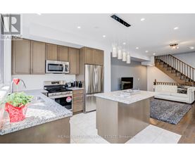A modern kitchen with a stainless steel refrigerator and a white island.