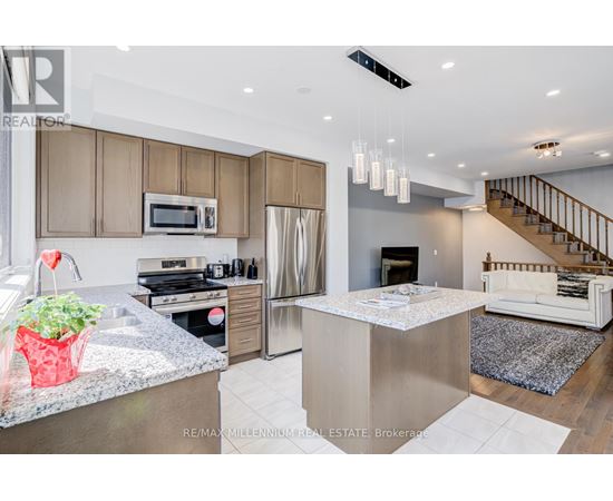 A modern kitchen with a stainless steel refrigerator and a white island.