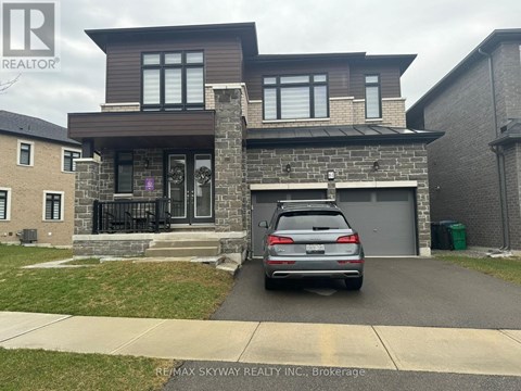 A house with a grey car in front of it.