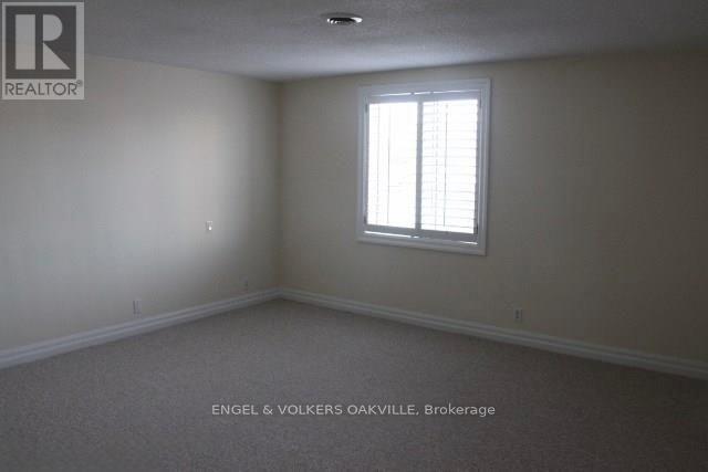 A room with a window and a carpeted floor.