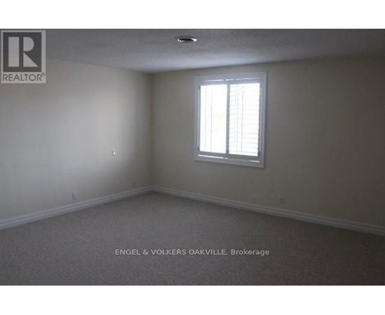 A room with a window and a carpeted floor.
